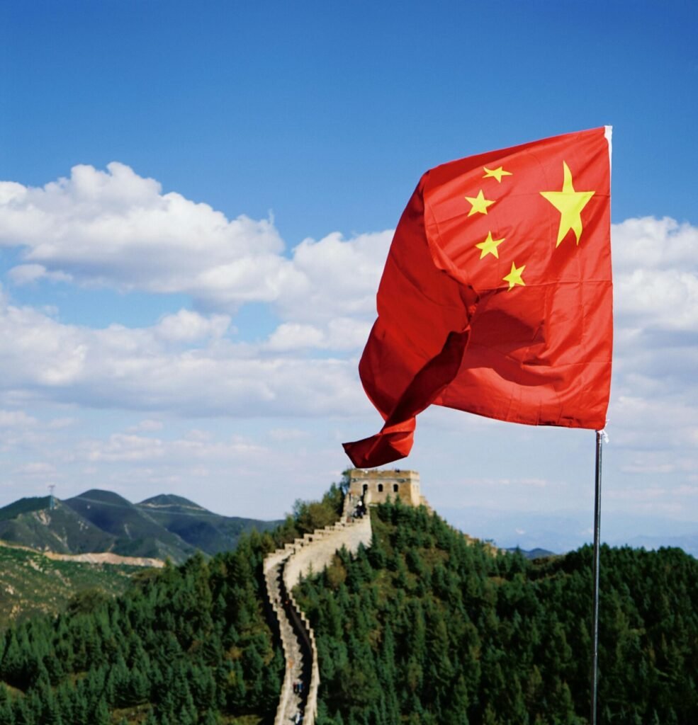 Scenic view of the Great Wall and Chinese flag under a clear blue sky, perfect for travel imagery.
